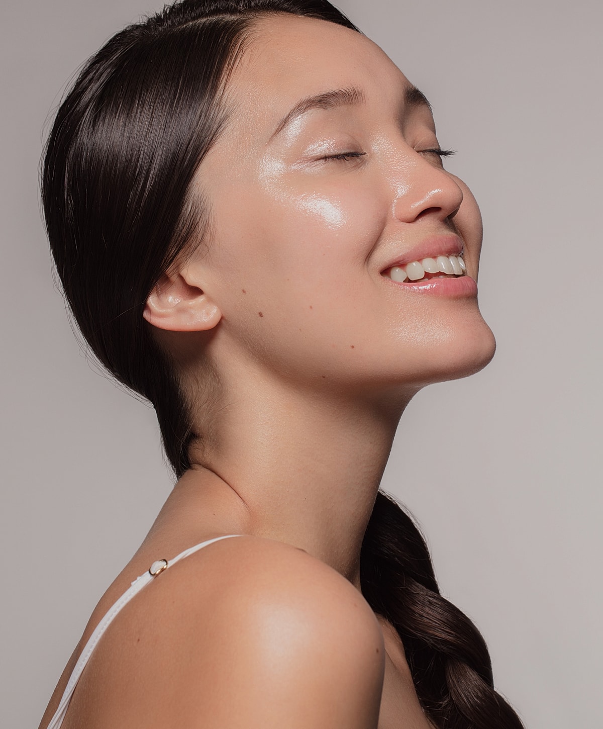 Model posing with hands raised and closed eyes.