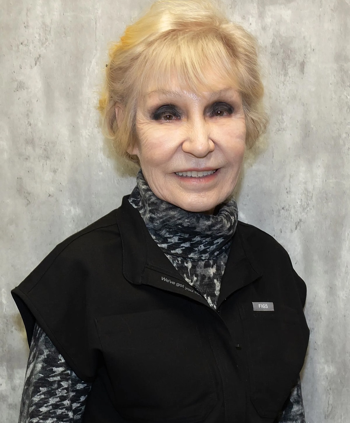 Smiling older woman in black uniform.