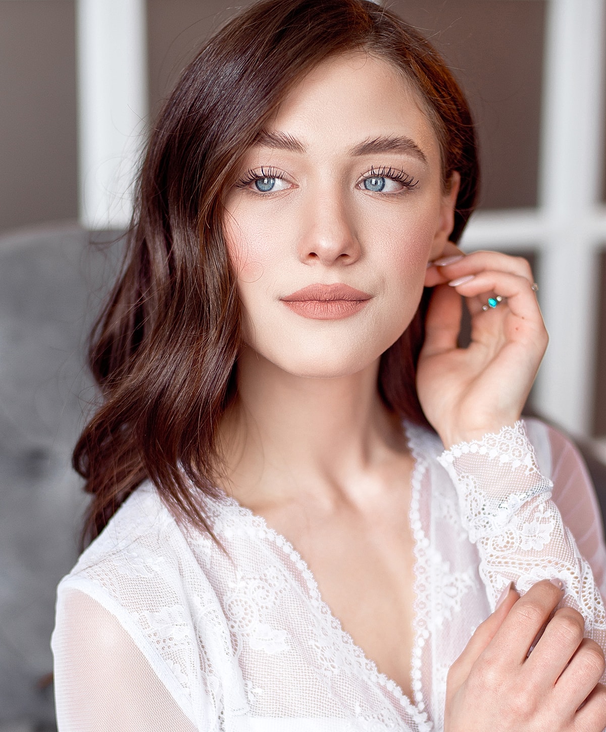 Model posing with hands raised and closed eyes.