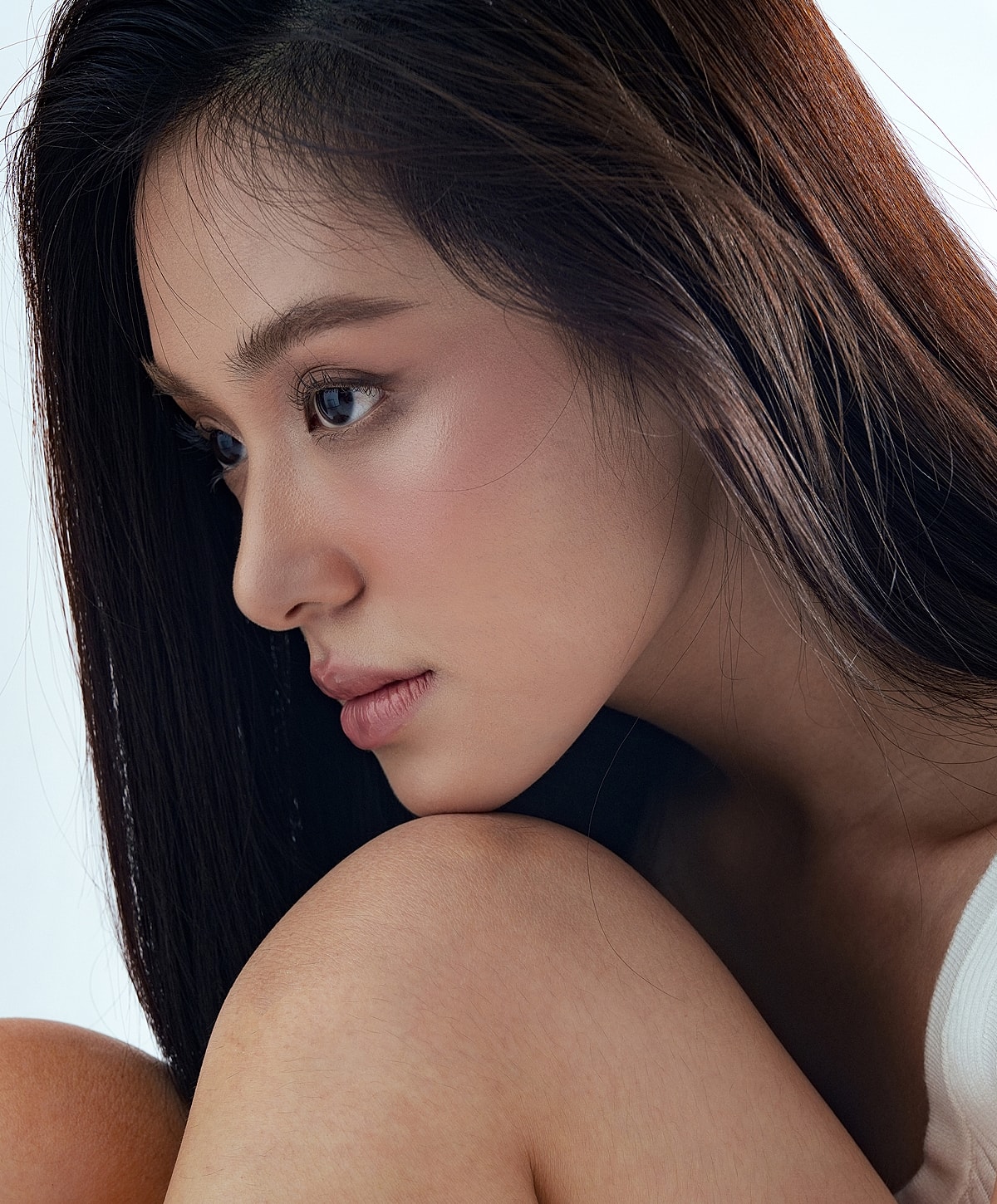 Model posing with hands raised and closed eyes.