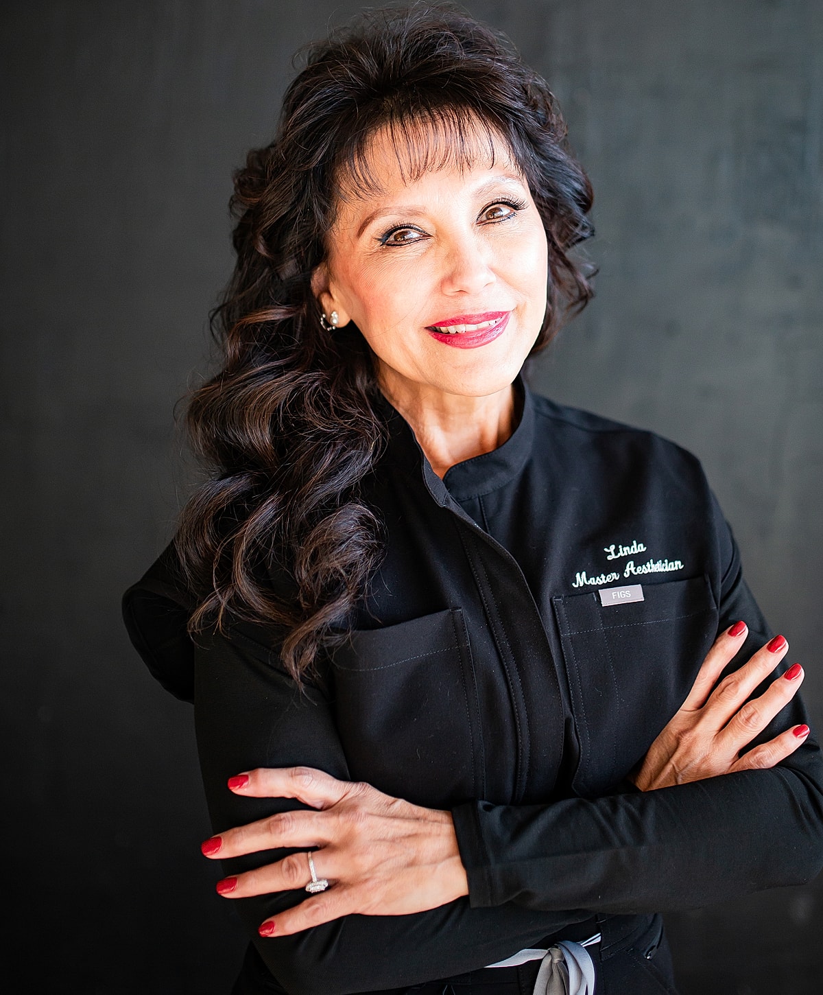 Woman in professional attire, smiling confidently.