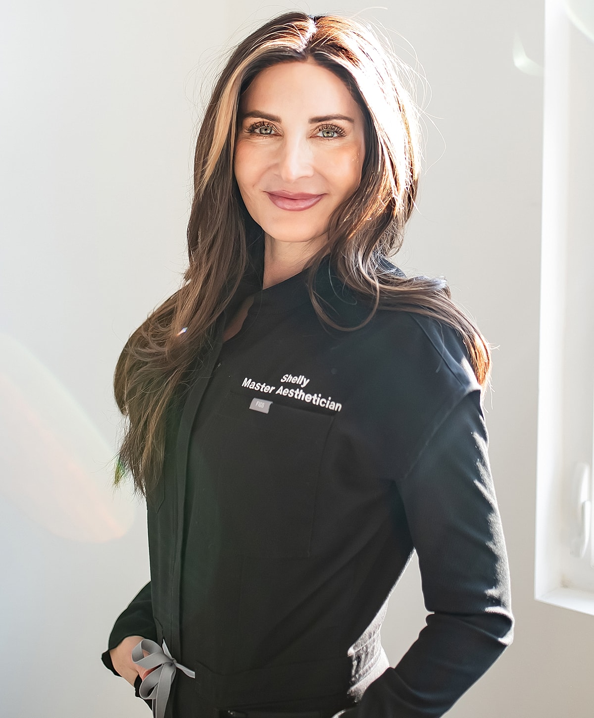 Master aesthetician smiling in professional attire.