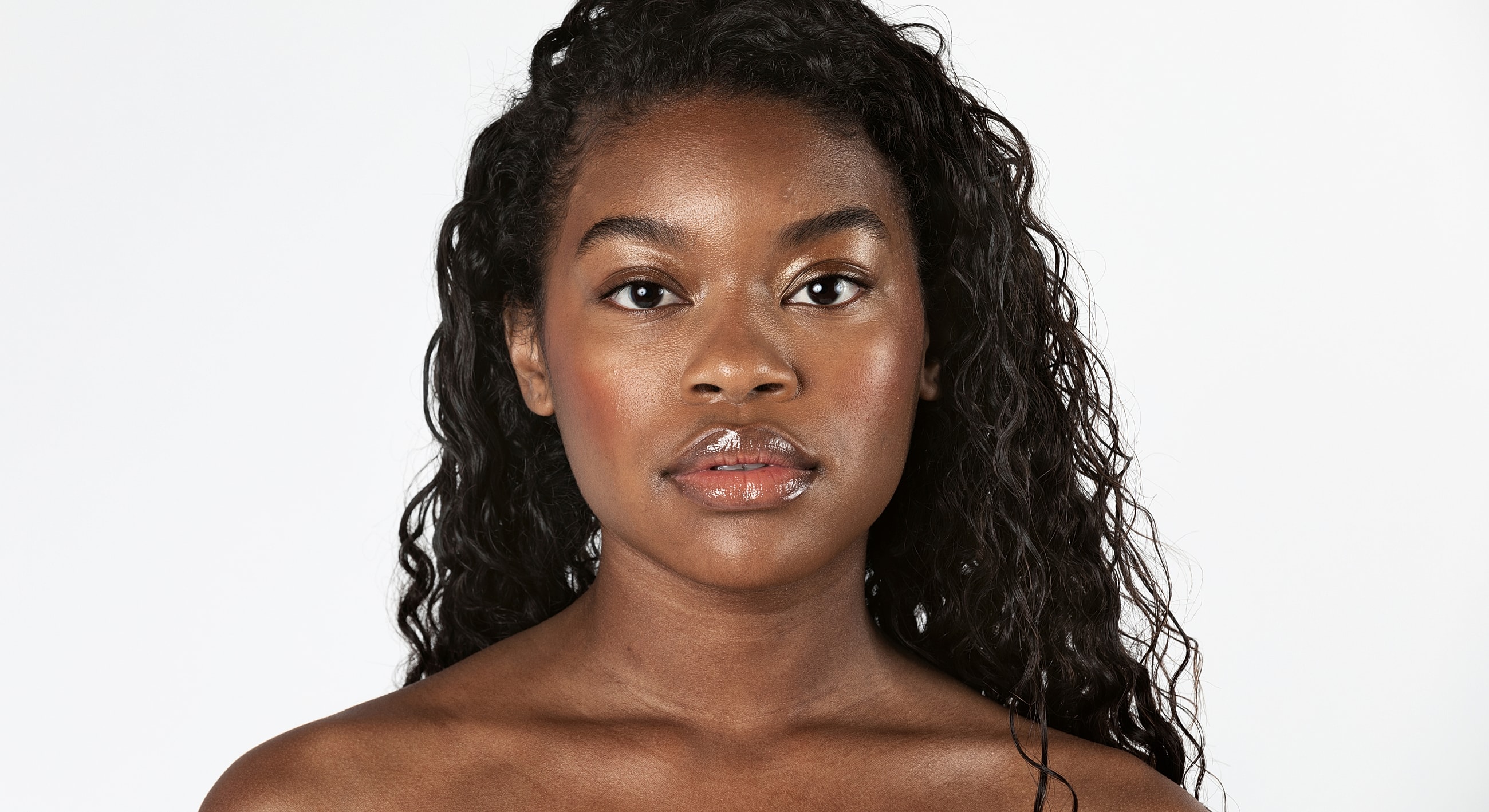 Woman with closed eyes wearing a black blazer.