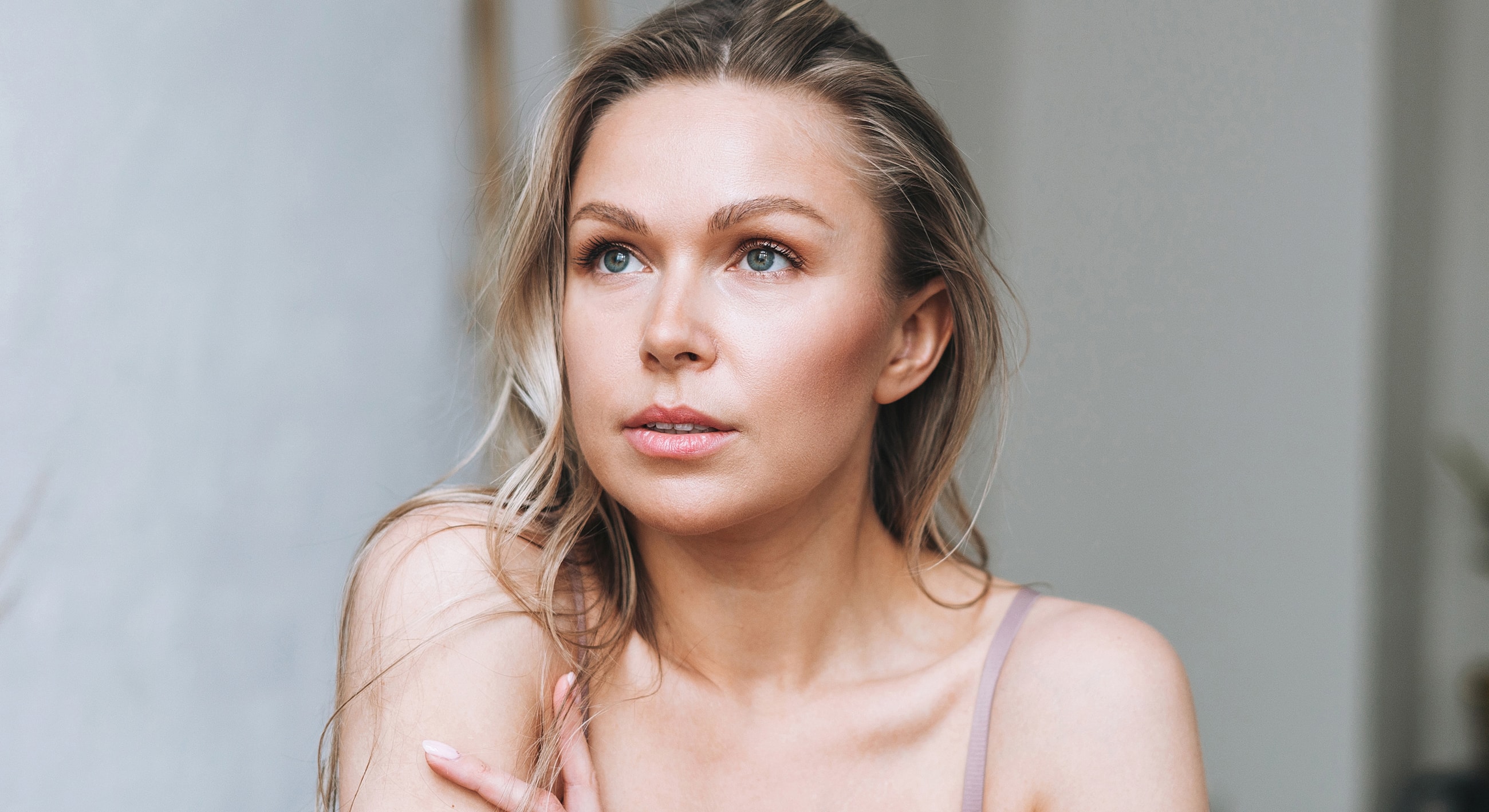 Smiling woman with long hair against white background.