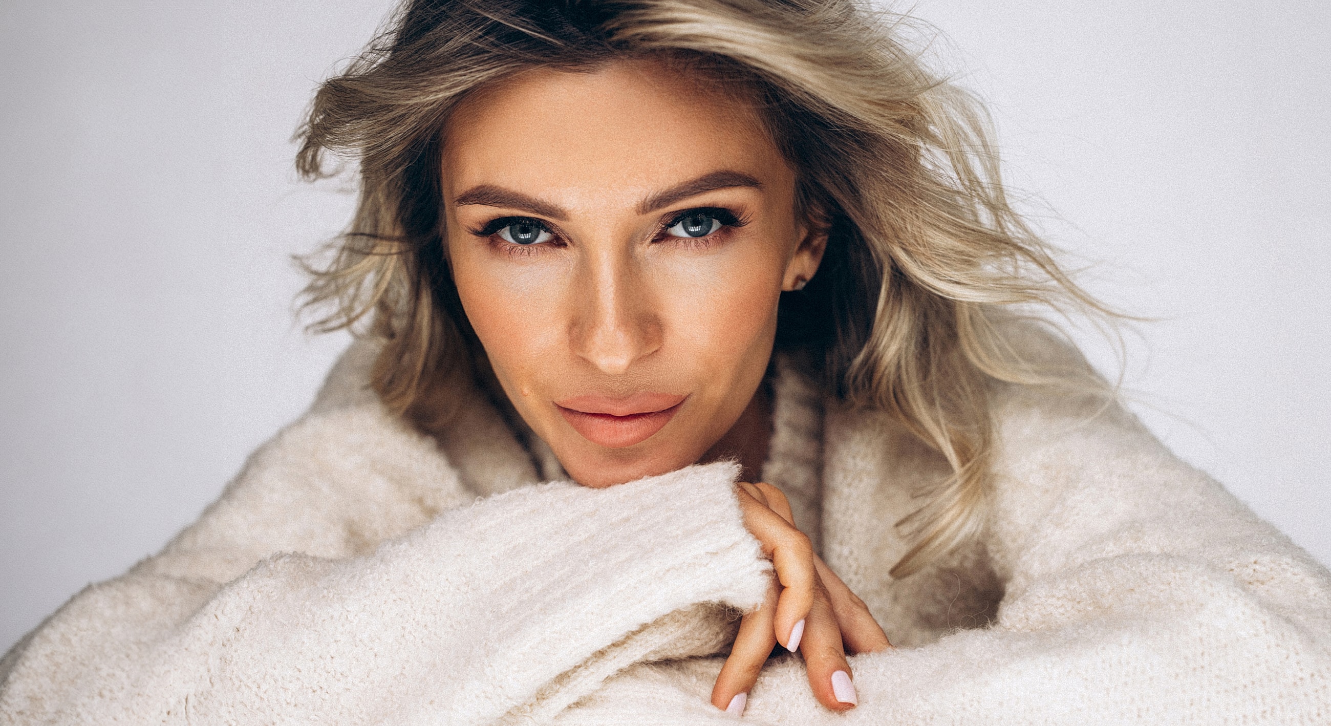 Person in cozy sweater with soft, flowing hair.