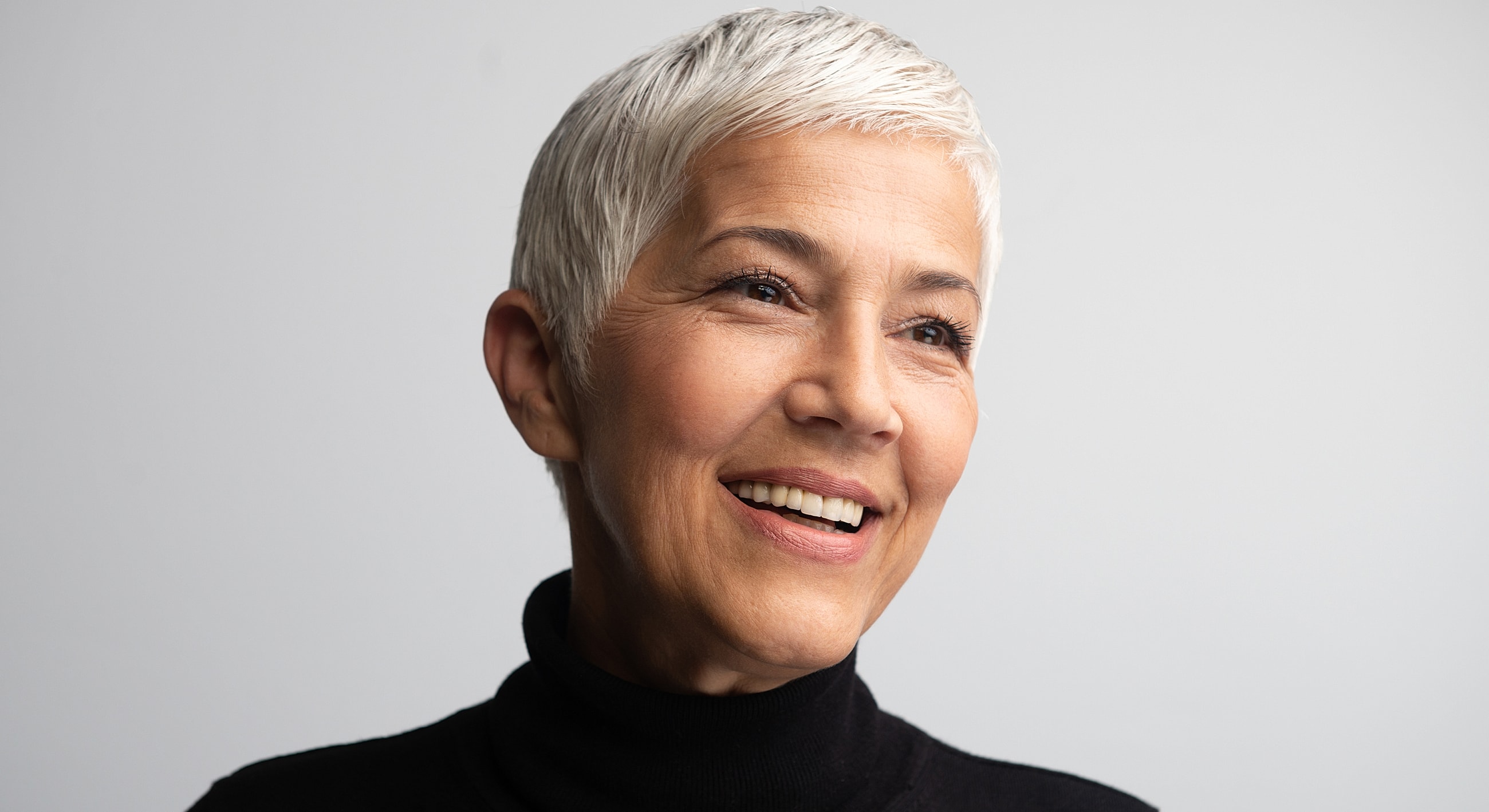 Smiling woman with short silver hair.